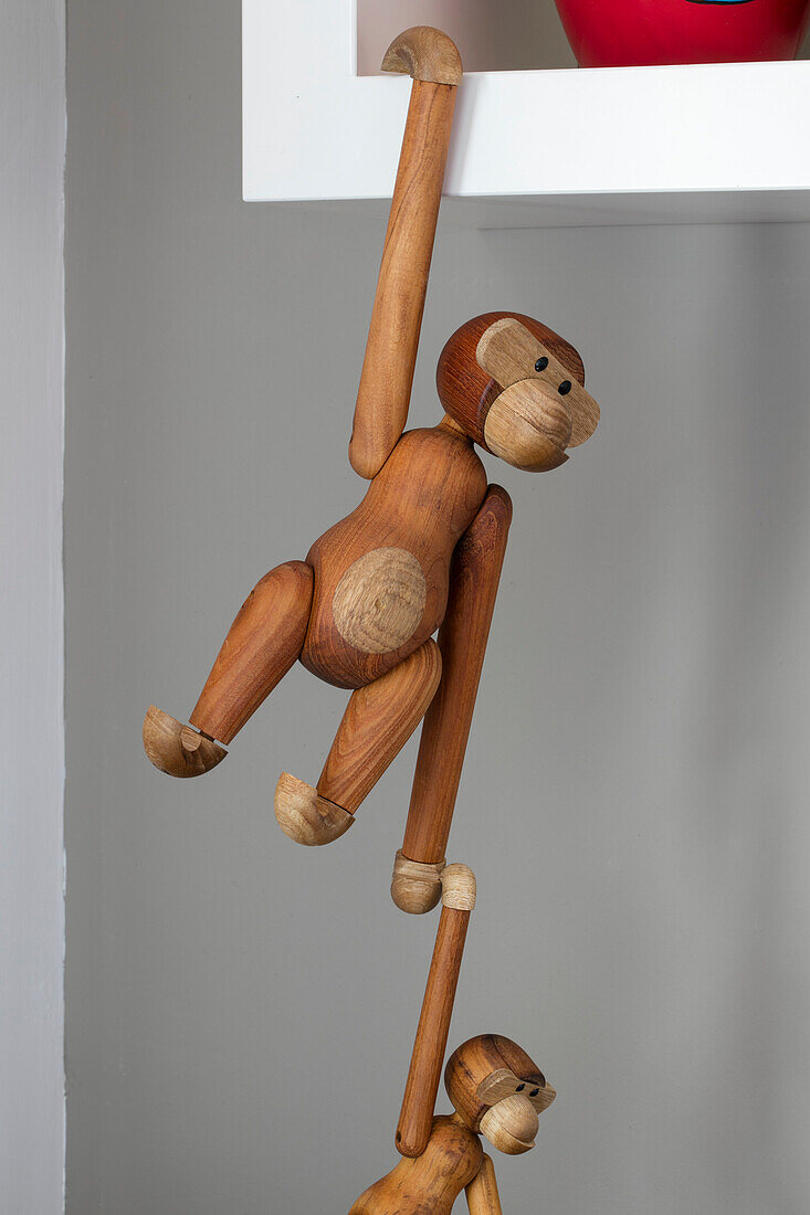 Wooden toy monkeys hang from shelf in North London home UK