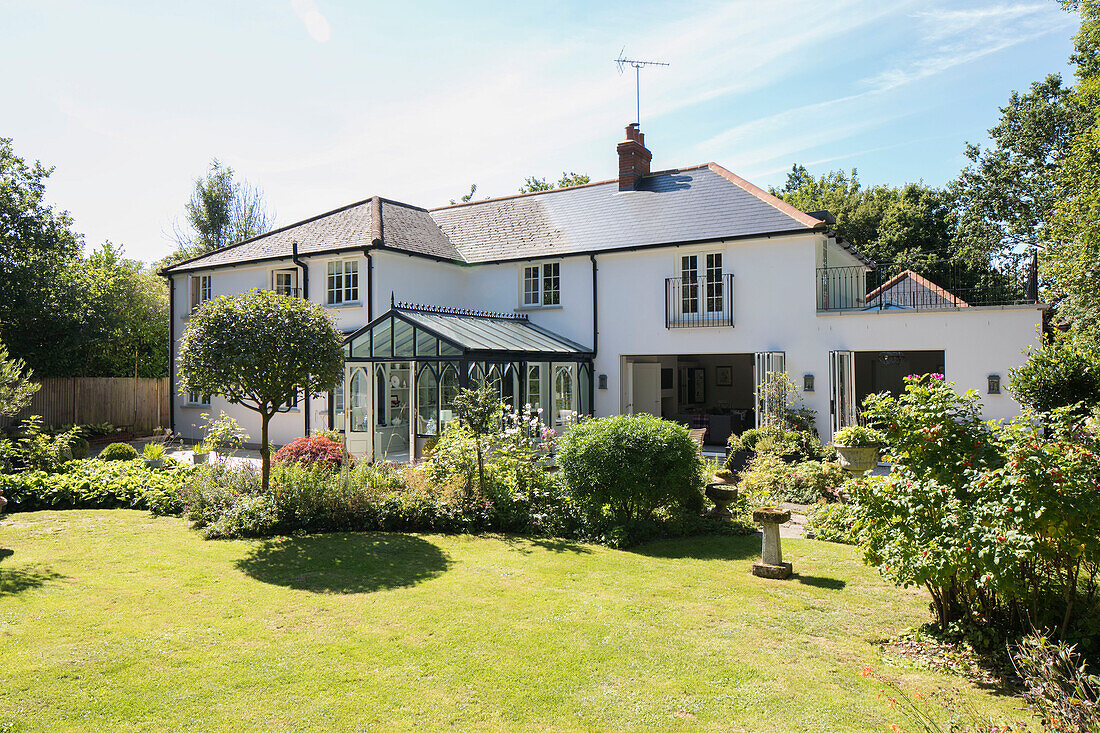 Sonnenbeschienener Garten und Rasen eines Einfamilienhauses in Sussex, Großbritannien