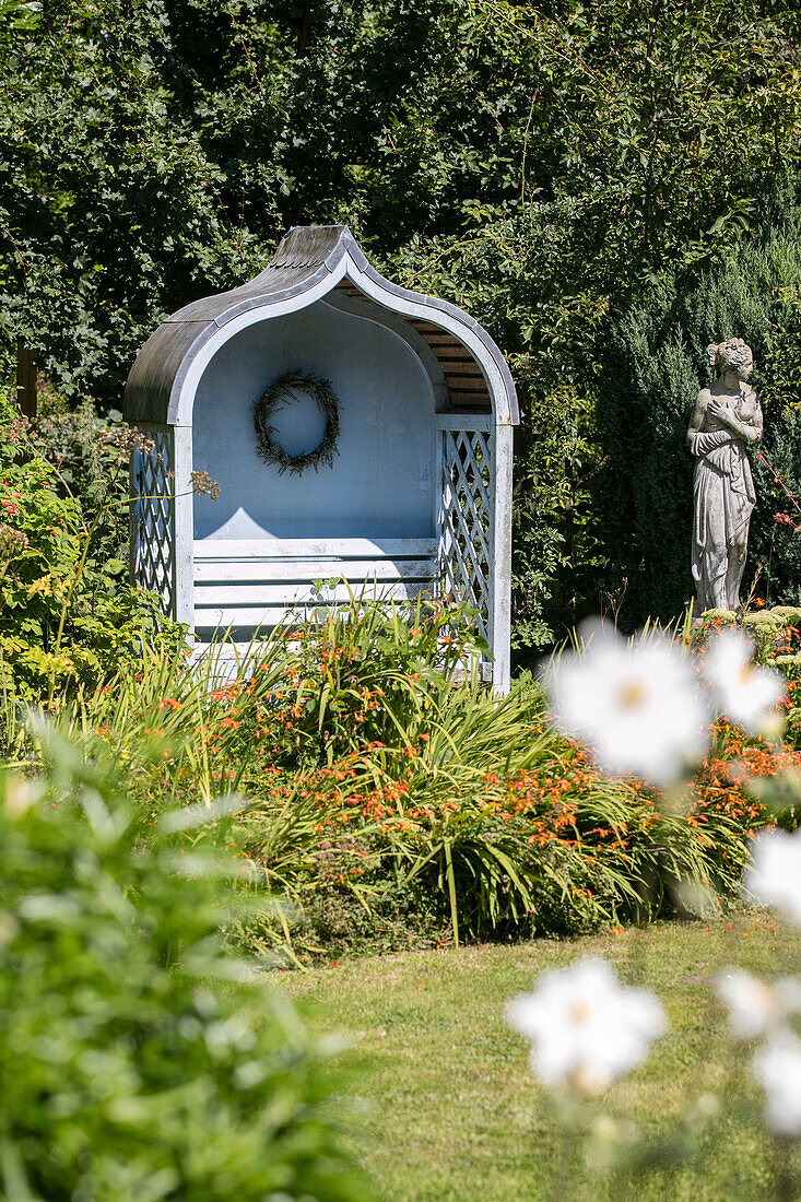 Hellblauer Pavillon und Statue im Garten eines Hauses in Sussex, UK