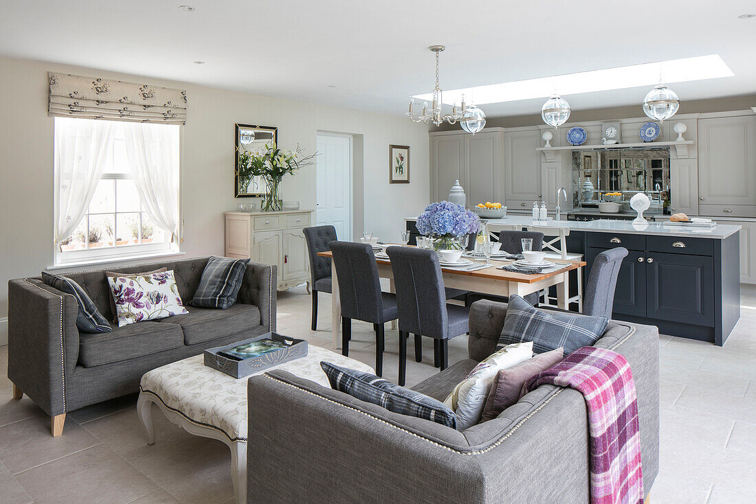 Open plan kitchen living room with open doors to garden in Sussex home UK