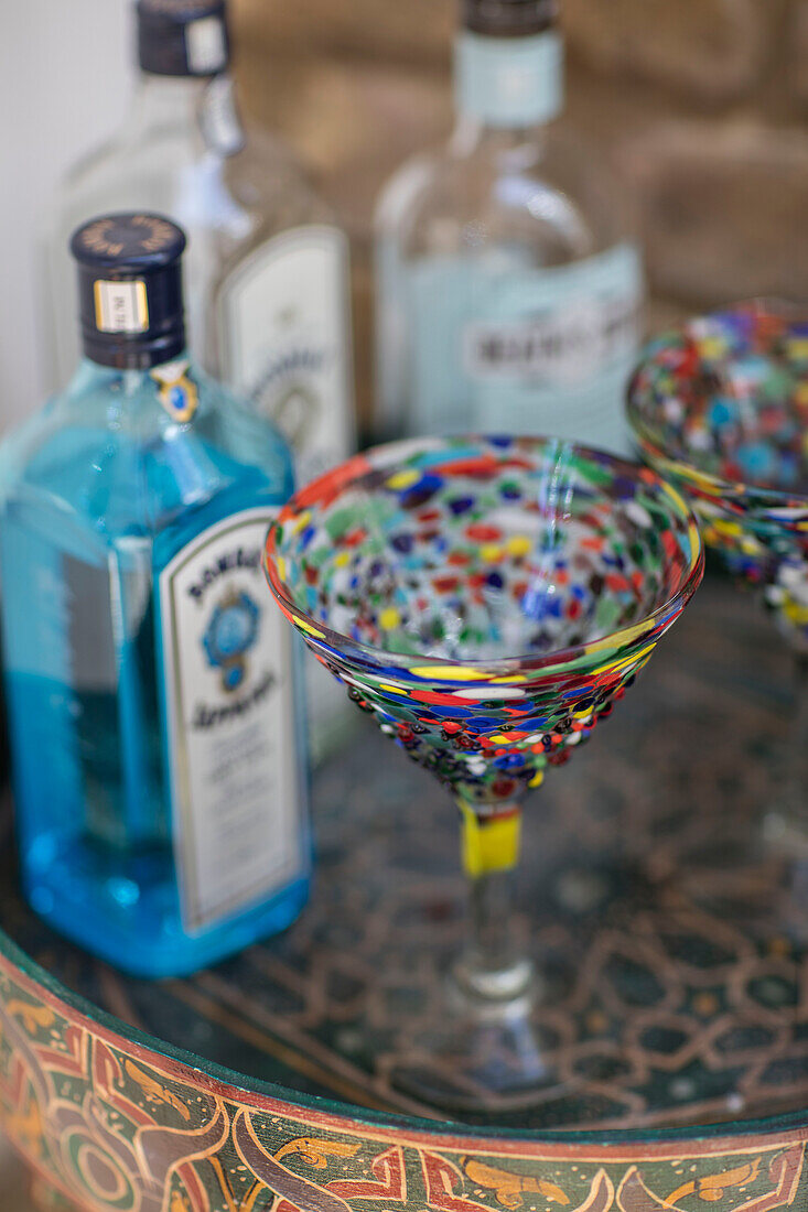 Colourful cocktail glass and bottles of spirits on tray in London home UK