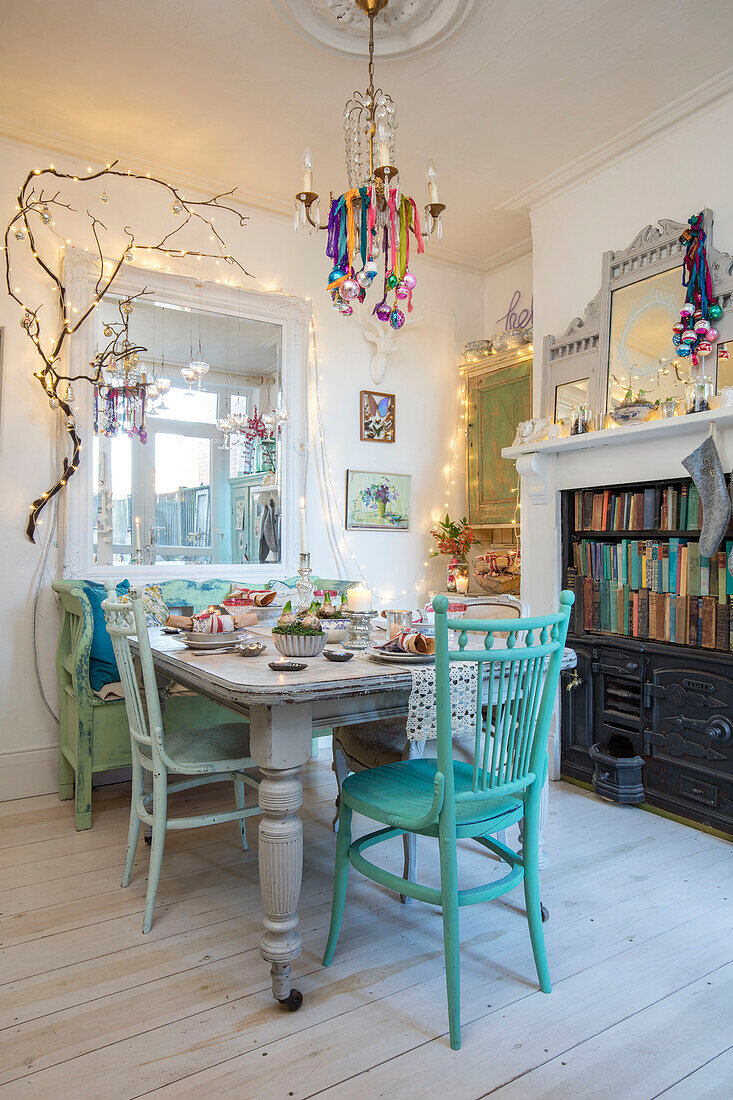 Gemalte Stühle in gemischten Farben mit Weihnachtskugeln und Bücherregal in einem Haus in Norwich Norfolk UK