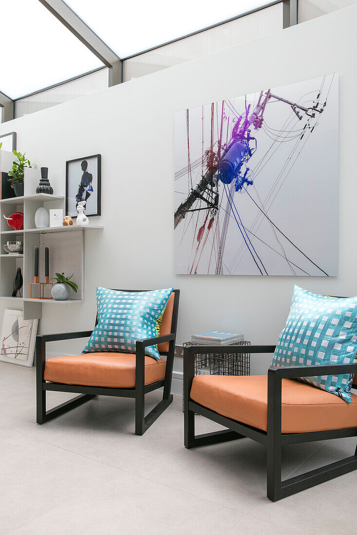 Zwei Sessel im Retrostil mit moderner Kunstleinwand in einem Londoner Haus UK