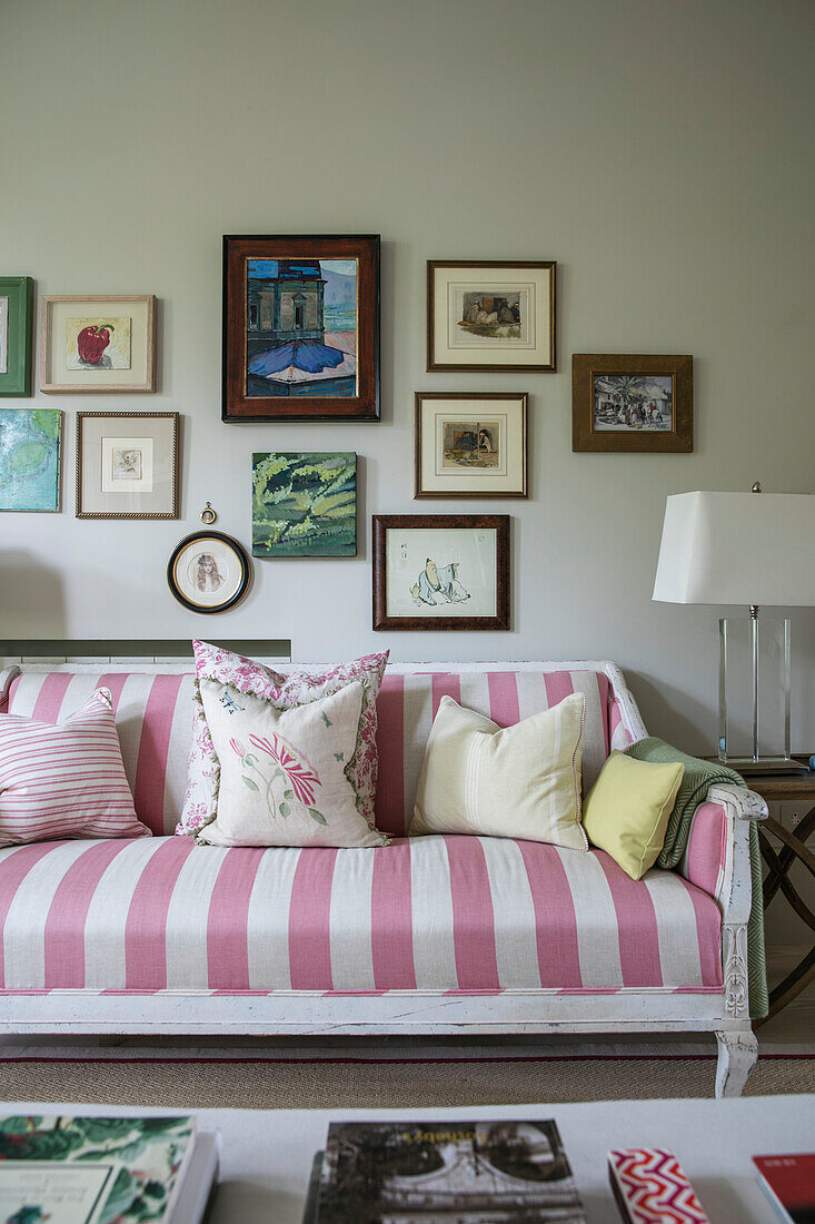 PInk and white striped sofa with picture wall in London living room UK