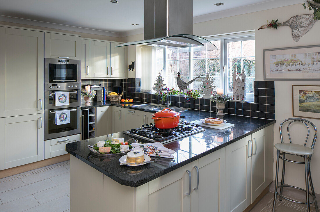 Casserole on kitchen hob units in Bone with black tiled splashback Herefordshire newbuild UK