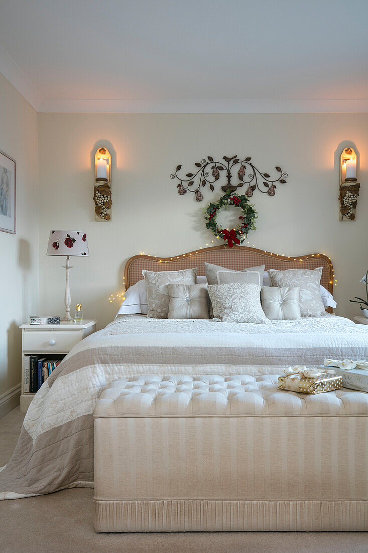 Fairylights am Kopfteil mit geknöpftem Bettkasten in einem Haus in Herefordshire, UK