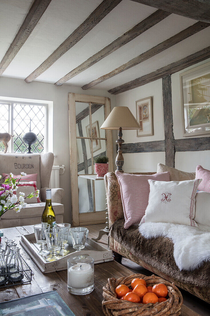 Striped cushions and salvaged door mirror with tray of glasses in Surrey farmhouse UK