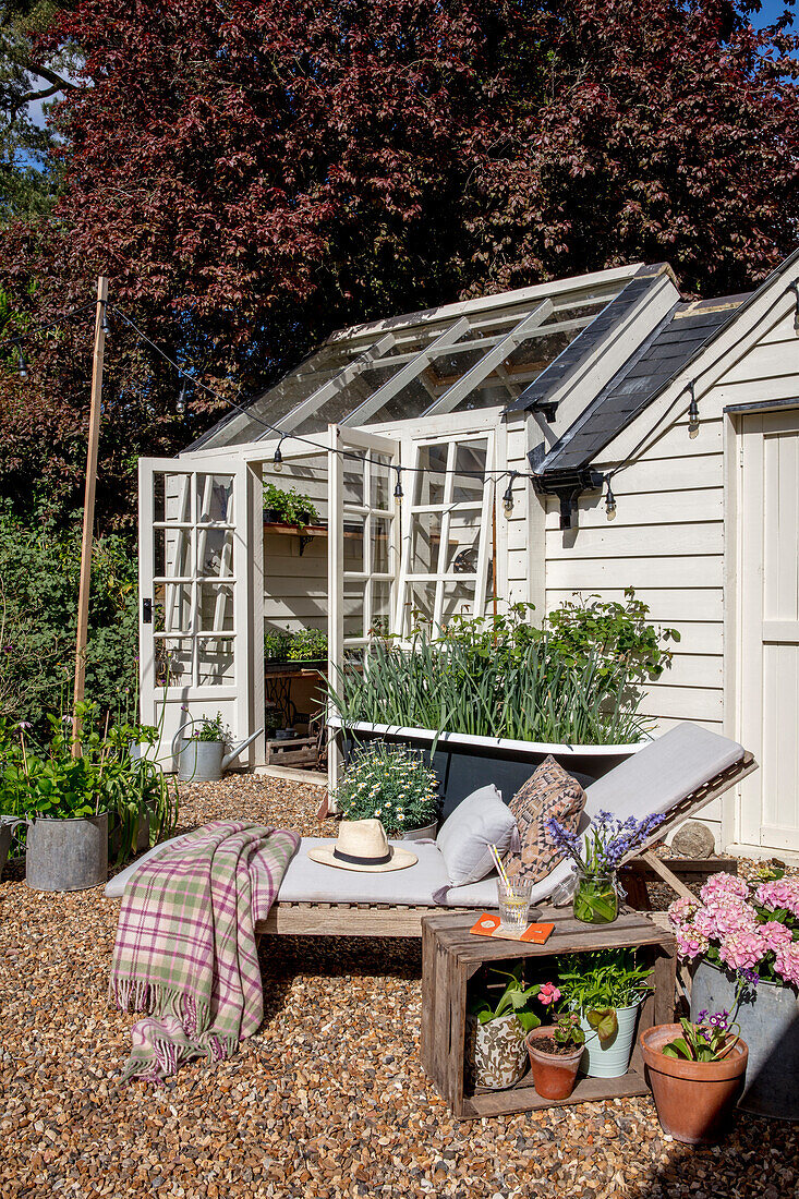 Greenhouse and sunlounger in Hertfordshire garden UK