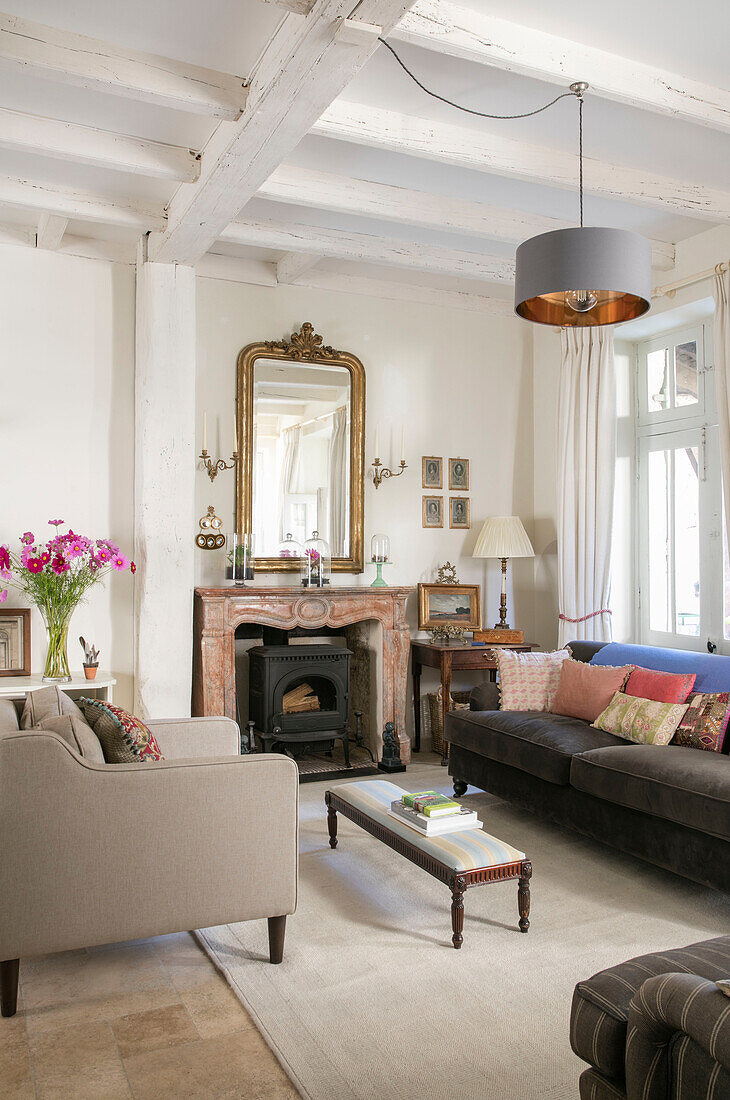 Armchair and sofa below grey pendant shade in Issigeac townhouse Perigord France