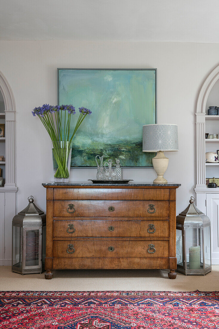 Kunstleinwand und Schnittblumen mit Laternen und Vintage-Holzanrichte in einem Haus in Hampshire England UK