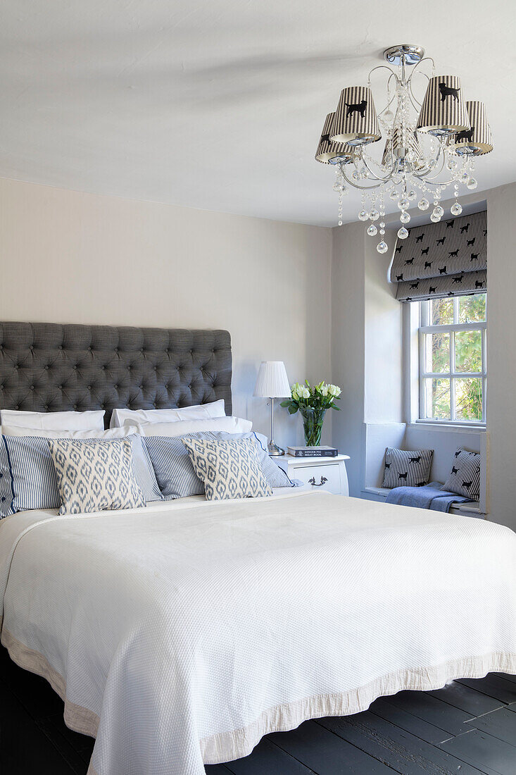 Grey and white bedroom with buttoned headboard and coordinated animal print fabrics in Wiltshire cottage UK