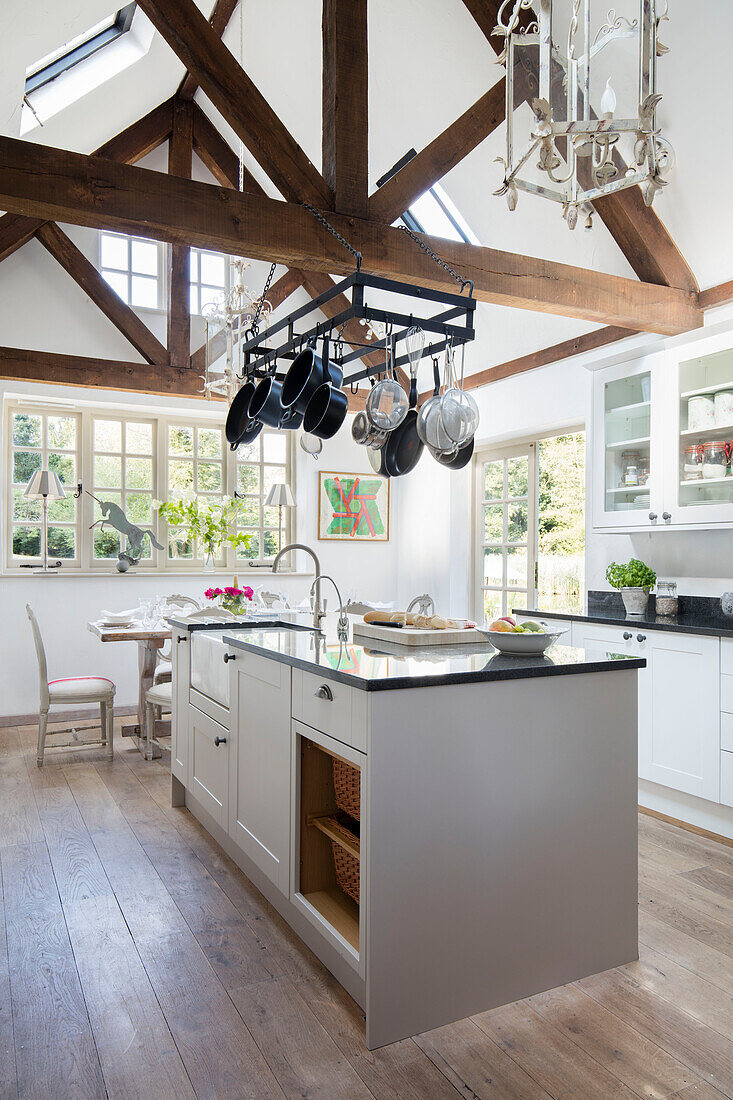Offene Küche mit Topfregal über der Kochinsel in einem Cottage mit doppelter Höhe in Surrey UK