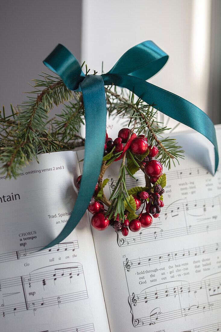 Sheet music with teal ribbon and red berry wreath in West Sussex UK