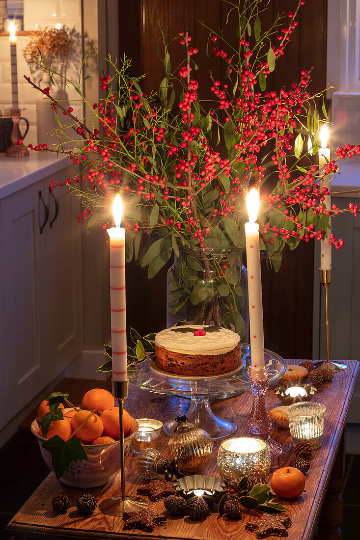 Weihnachtskuchen und brennende Kerzen in der Küche eines Cottage in Hampshire, Großbritannien