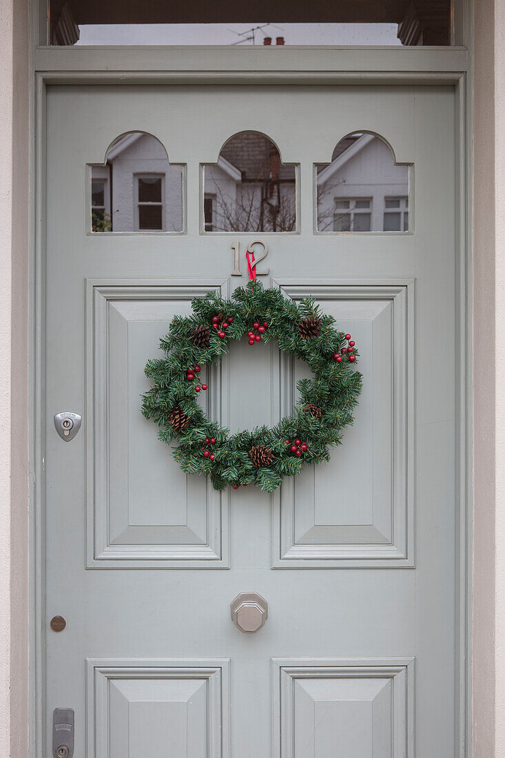 Weihnachtskranz mit hellgrauem Anstrich an der Tür von Hausnummer 12 London UK