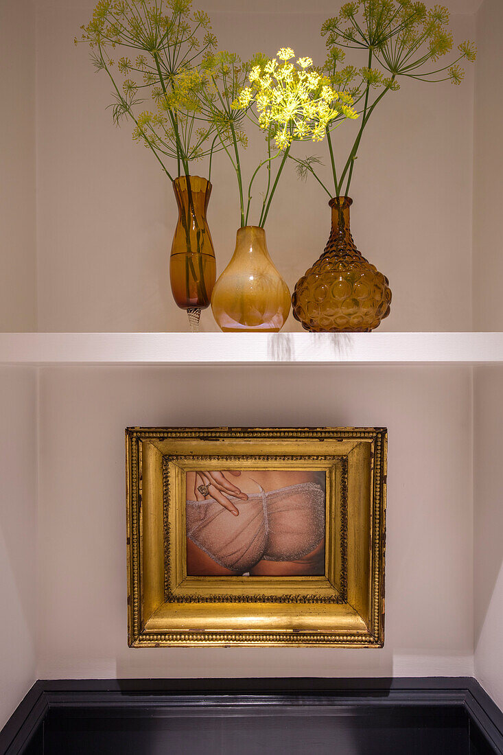 Gilt framed artwork with flowers in amber vases London townhouse UK