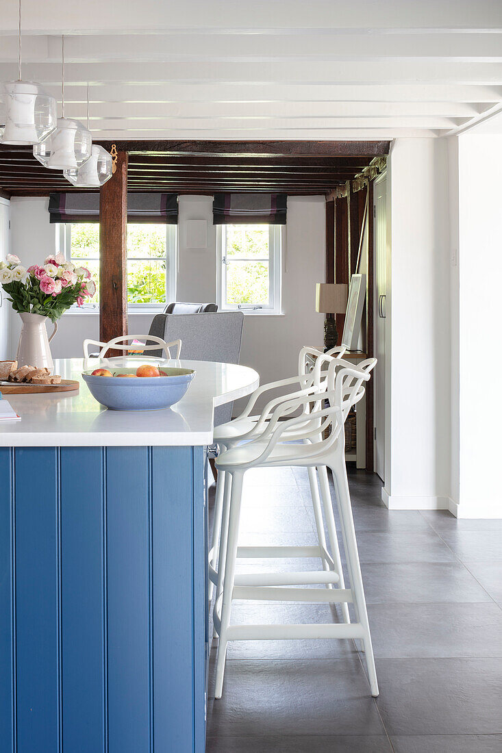 White bar stools at blue kitchen island with ceramic slate floor tiles Surrey UK