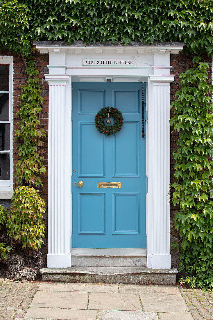 Hellblaue Eingangstür eines unter Denkmalschutz stehenden georgianischen Landhauses in West Sussex UK