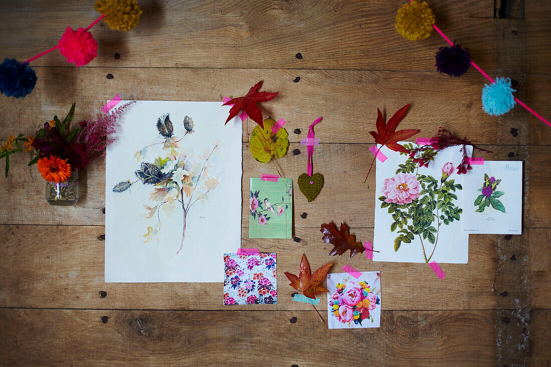 Botanic artwork and leaves with pompom garland in rustic wood cabin Autumn UK