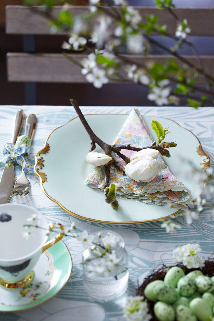 Gedeckter Ostertisch mit Magnolienknospen und -blüten