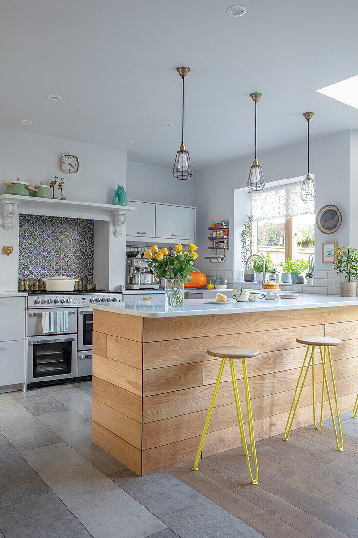 Open plan kitchen with light grey worktops and bar stools Sussex UK