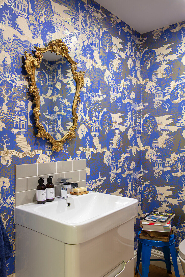 Orientalische Tapete mit goldgerahmtem Spiegel über dem Waschbecken Sussex UK
