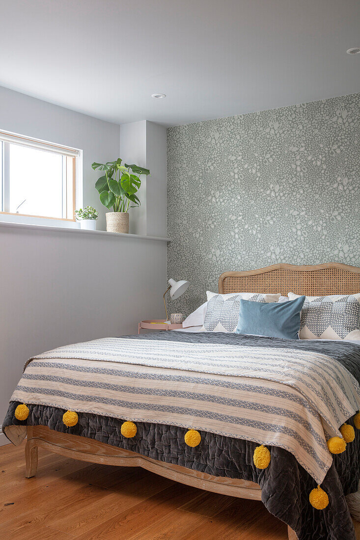 Gestreifte Decke mit gelben Quasten auf Bett mit Weidenkopfteil Sussex UK