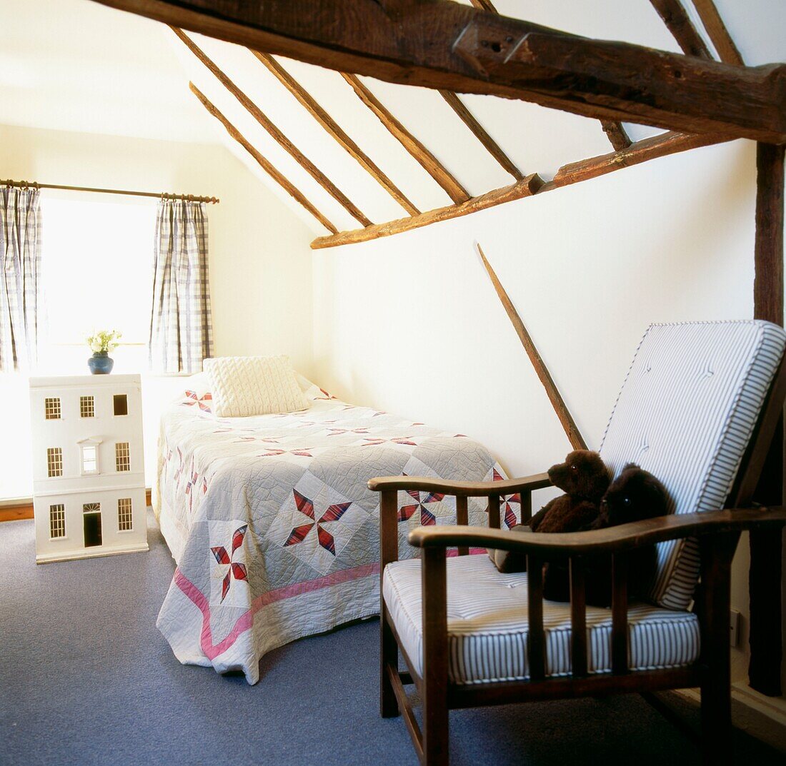 Schlafzimmer im Dachgeschoss mit Eichenbalken und antiker amerikanischer Steppdecke