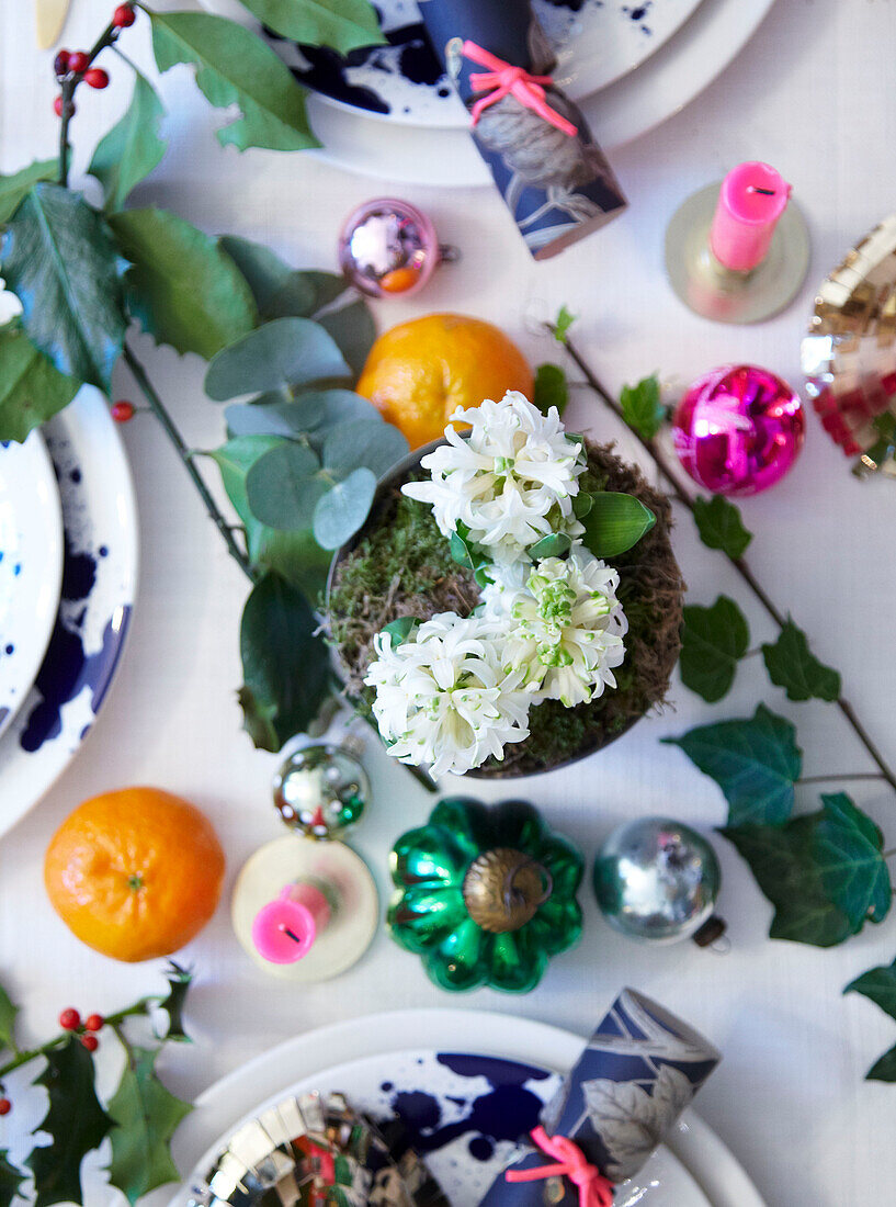 Detail eines Blumenarrangements auf einem weihnachtlich gedeckten Tisch