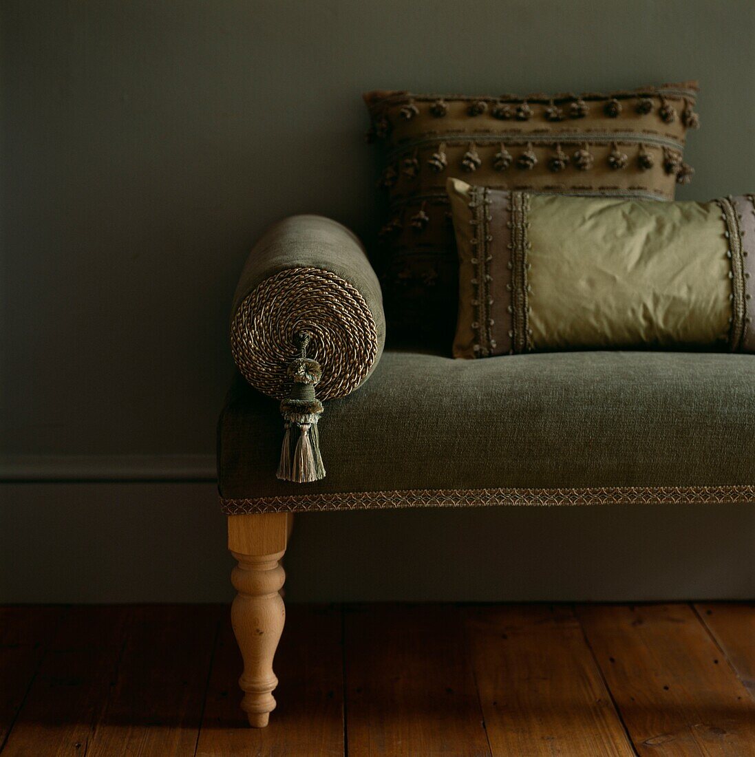 Green upholstered seat with decorative cushions