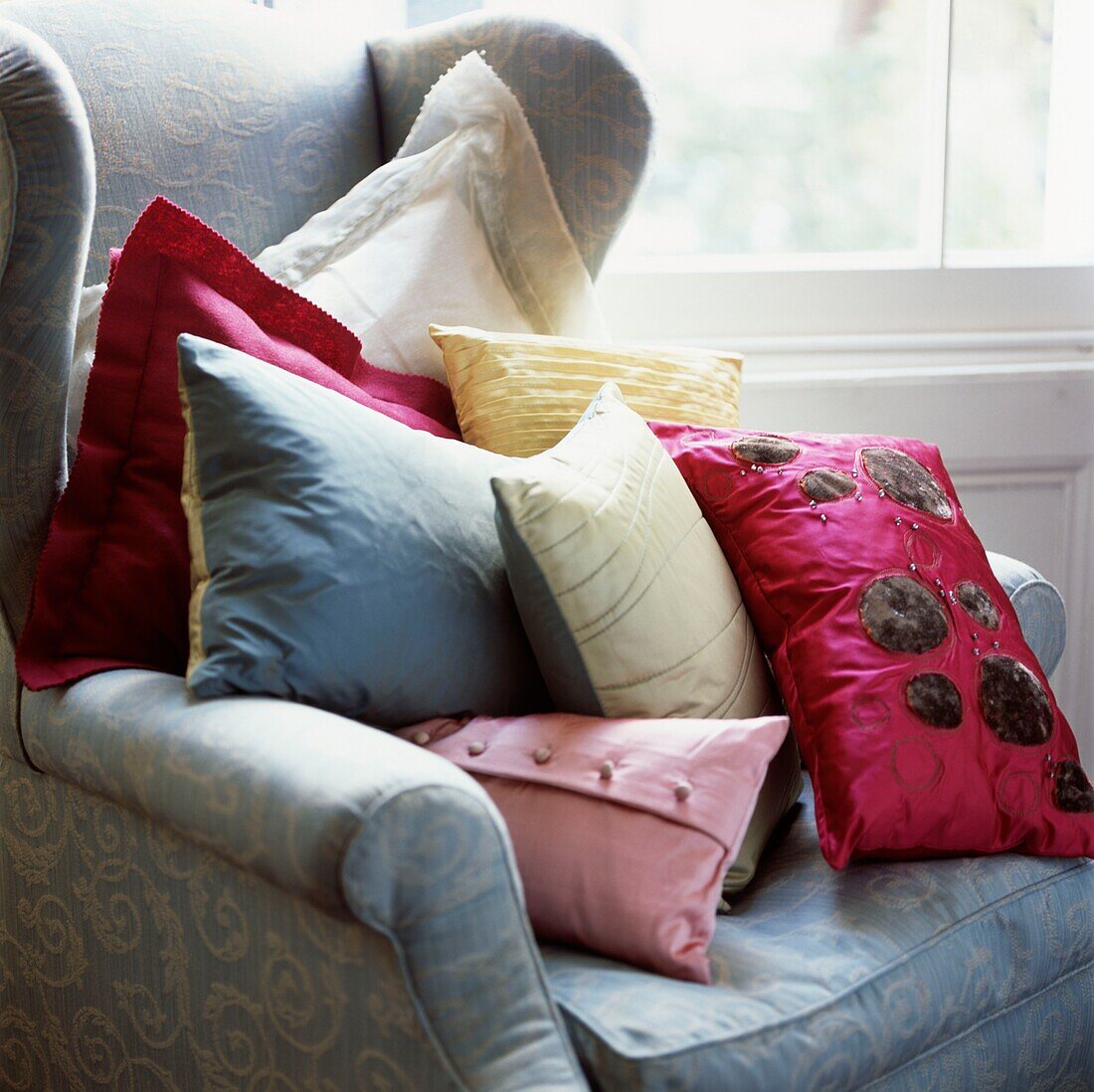 Pile of colourful cushions on an armchair