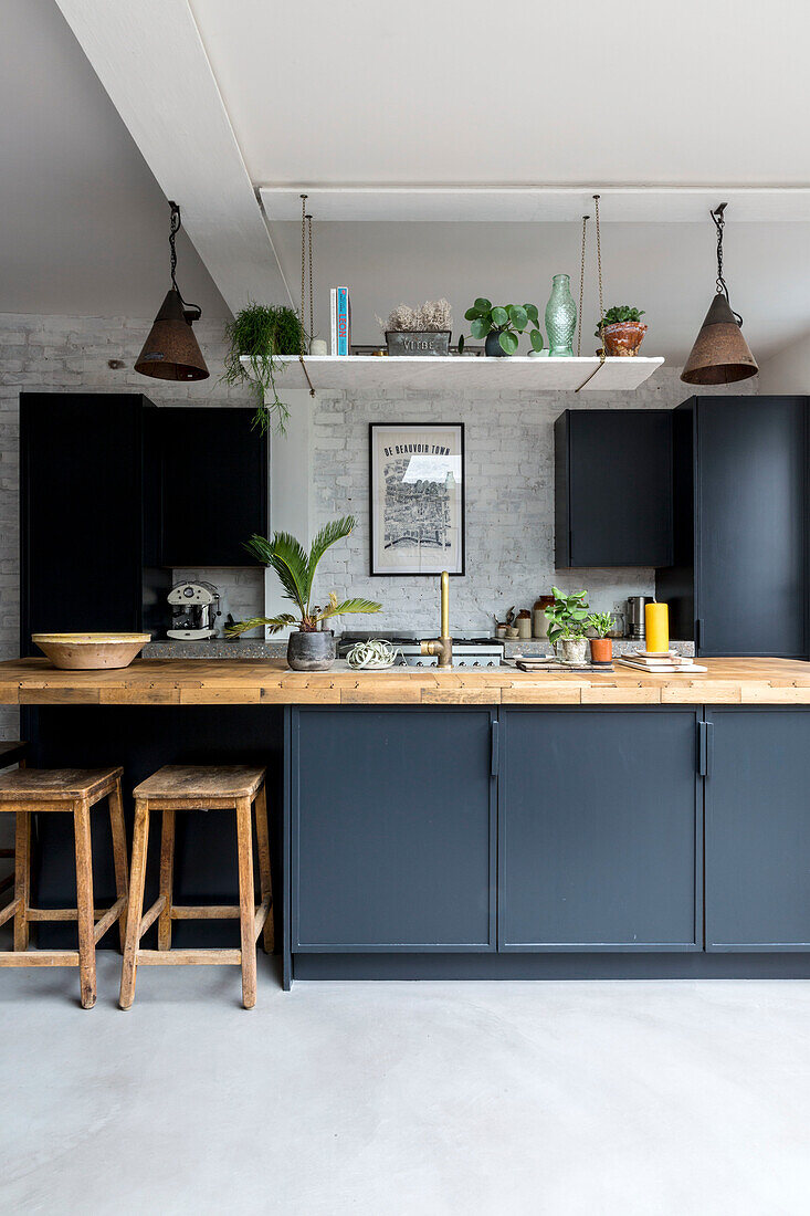 Modern kitchen unit in black with wooden accents and plants
