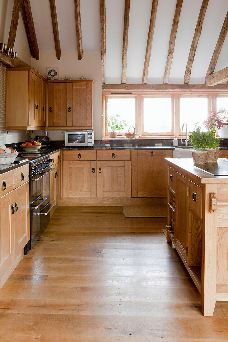 Fitted kitchen cabinets with wooden fronts in a converted barn