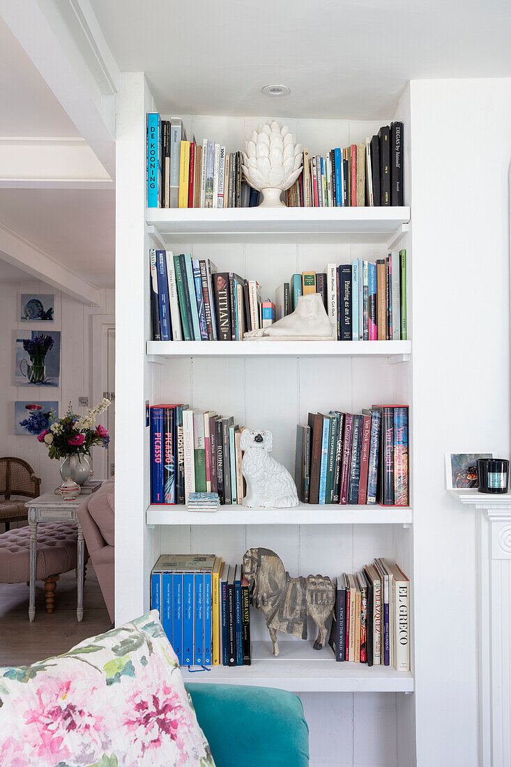 Shelf with books and decorative figurines in the bright living room