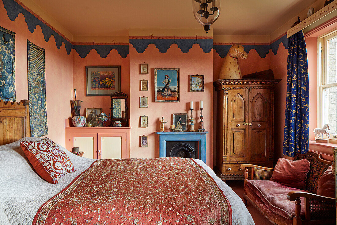 Bedroom with antique wardrobe, fireplace and blue and red decoration