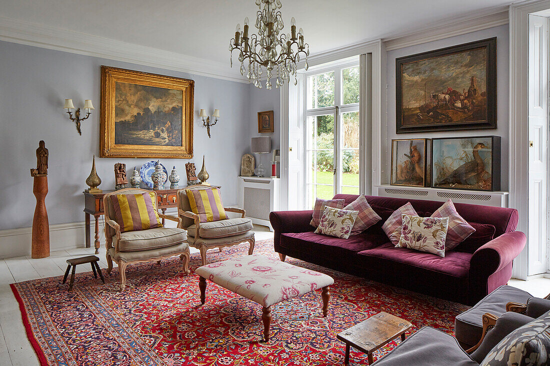 Elegant lounge with upholstered furniture, antiques, and collection of paintings