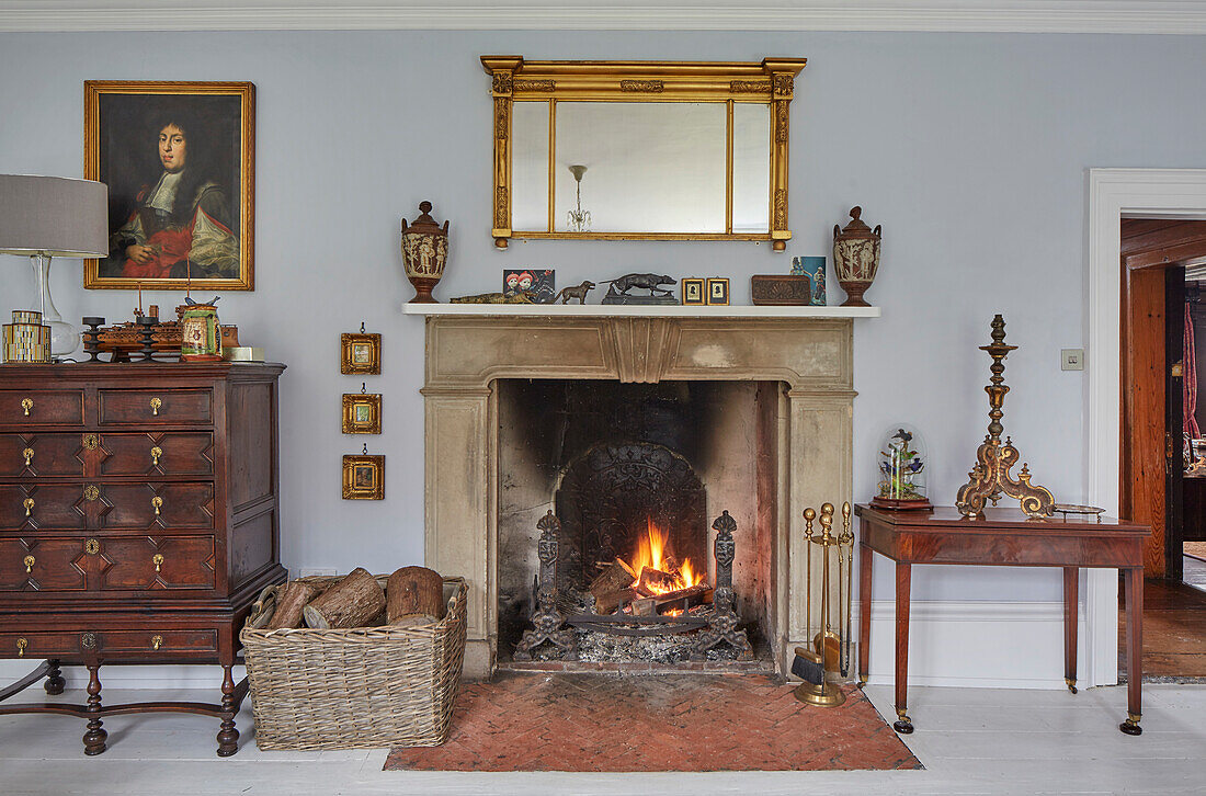 Fireplace between antique chest of drawers and console table
