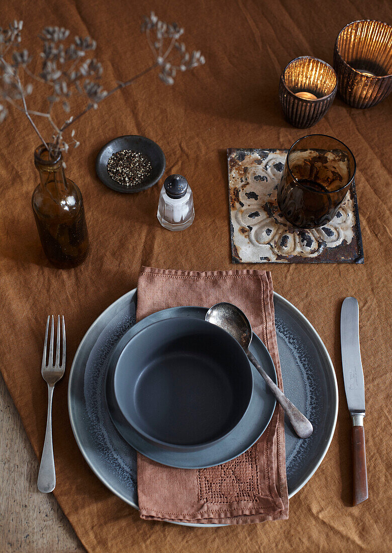 Set table with brown cloth napkins and ceramic crockery