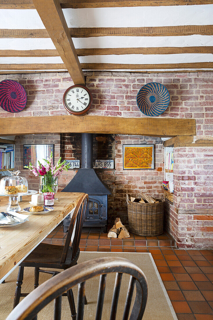 Dining area with woodstove and exposed wooden beams, set table