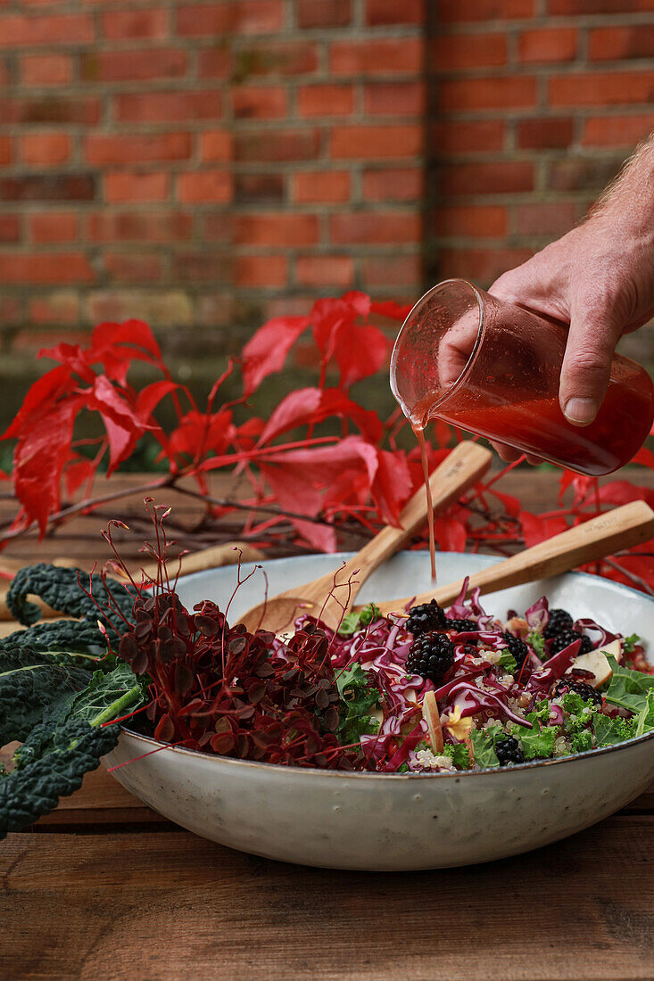 Dressing a kale and blackberry autumn salad
