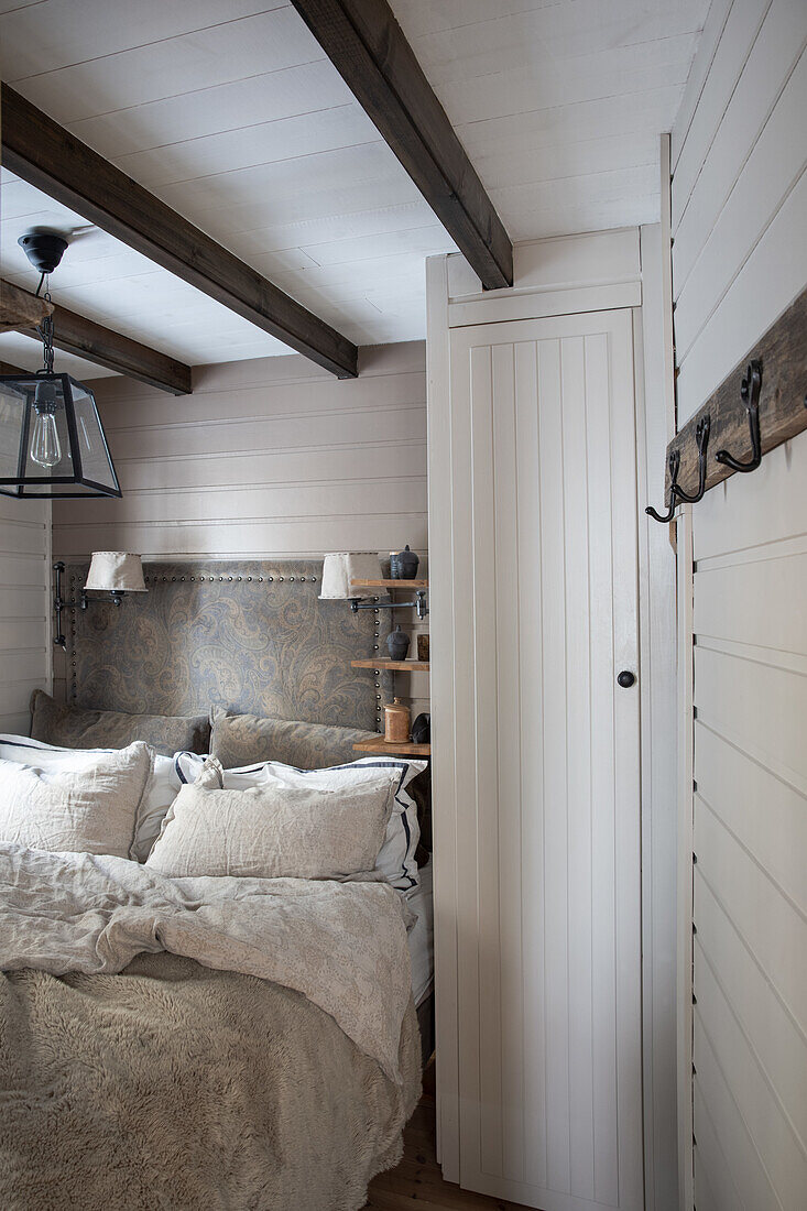 Country-style bedroom with wood paneling and exposed beams