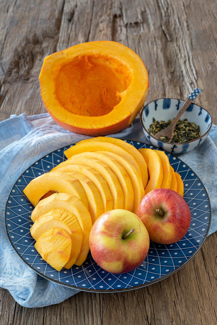 Pumpkin slices and apples on a blue plate