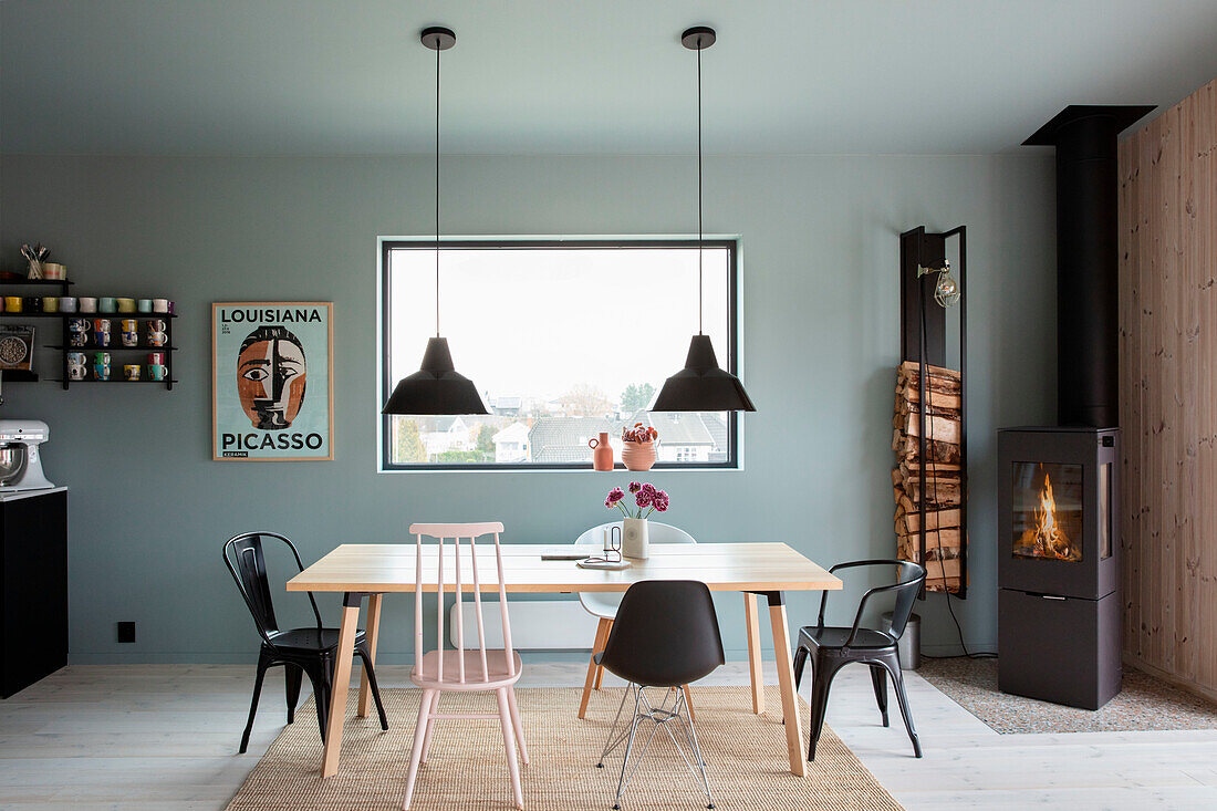 Dining area with wooden table, various chairs and wood-burning stove