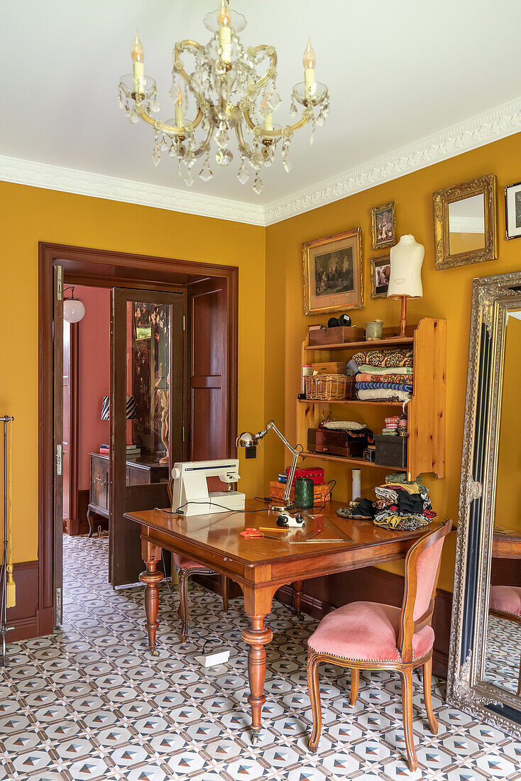 Arbeitszimmer mit antikem Schreibtisch und ockerfarbenen Wänden