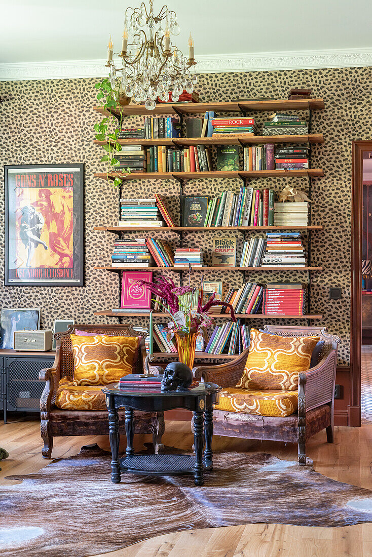 Bücherregal mit vielfältigen Büchern und zwei Rattan-Sesseln im Vintage-Stil