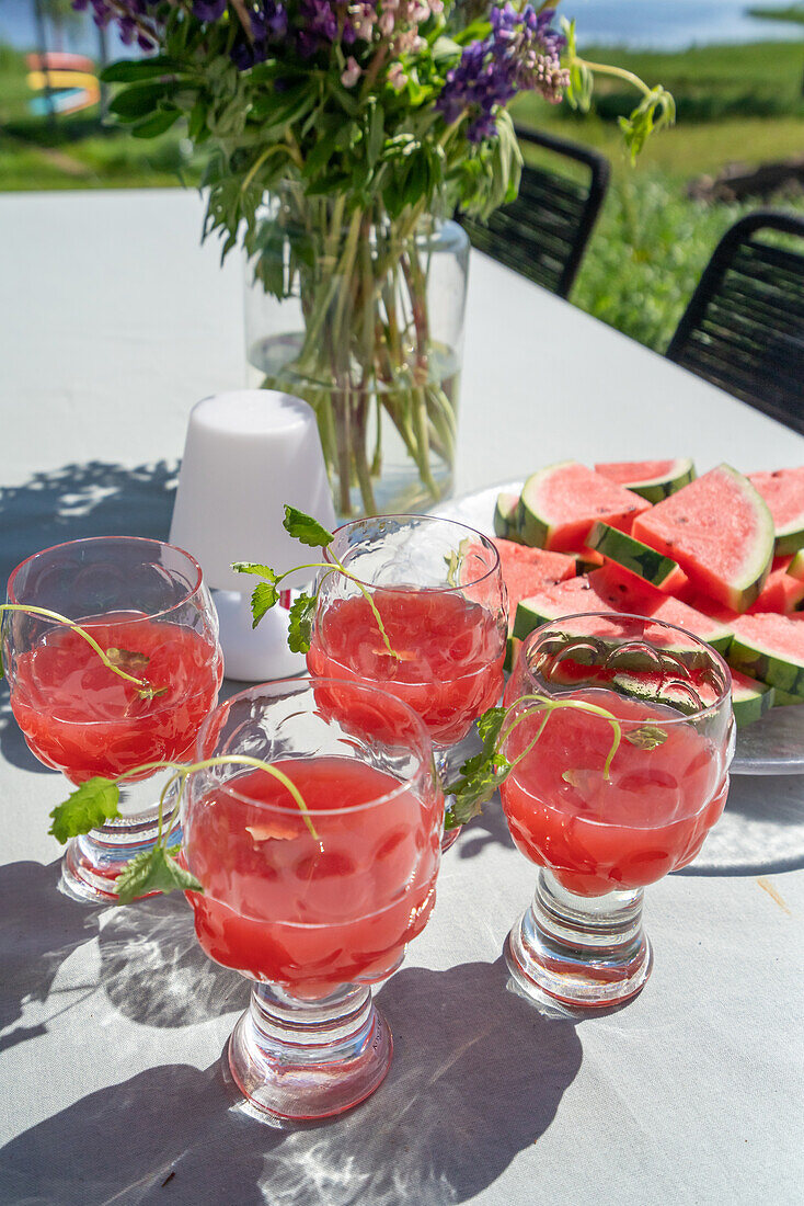 Watermelon drink with mint on patio table in summer