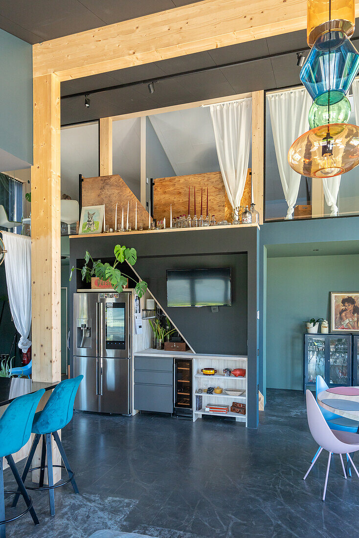 Open loft living room with modern kitchen, dining area and colourful pendant light