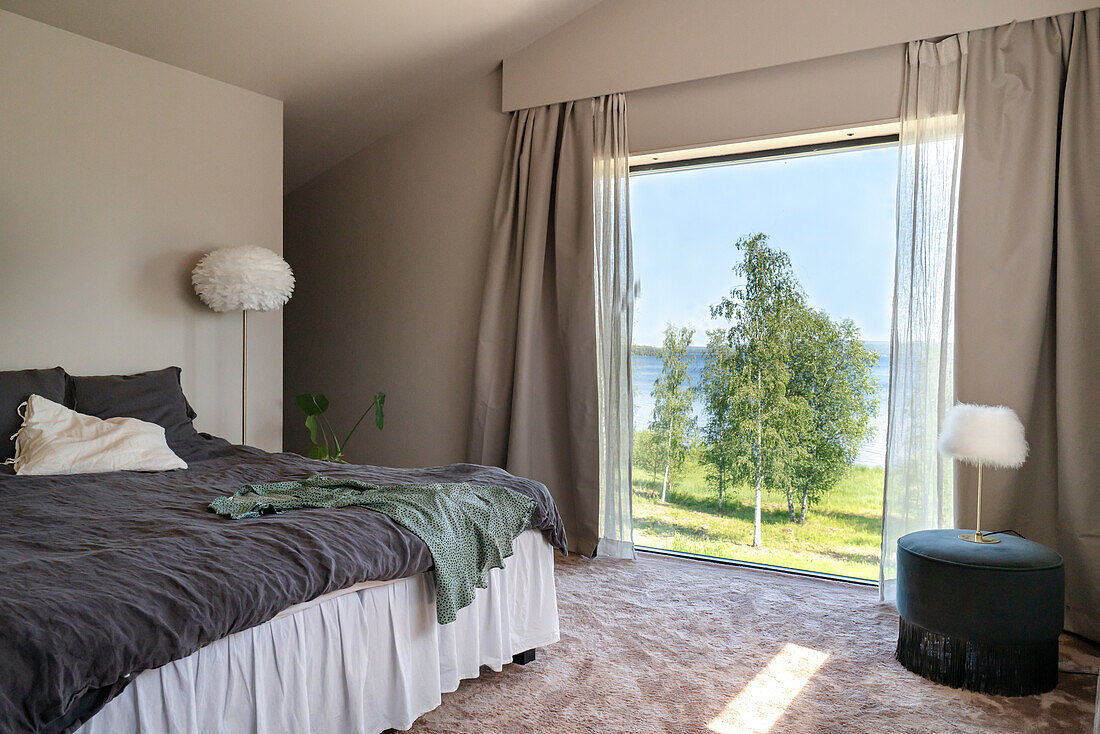 Schlafzimmer mit Panoramafenster und Ausblick auf die Landschaft