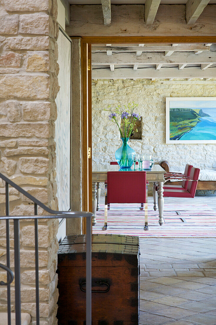 Rustic entrance area with view of dining area with stone wall