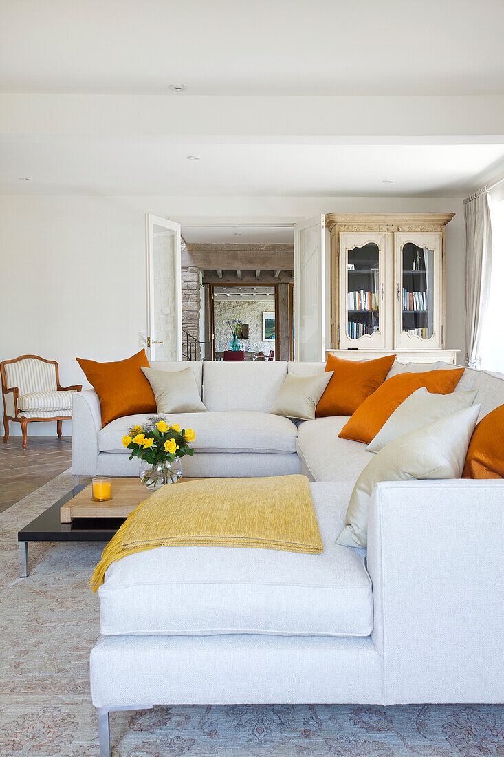 Bright living room with white sofas and orange accents